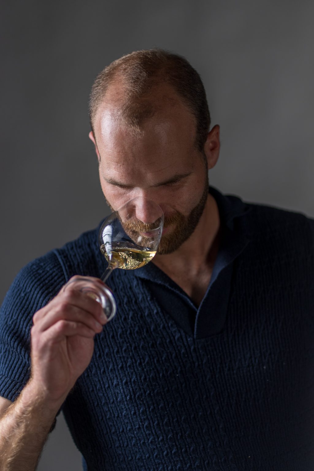 Thibault Ragot, caviste animateur en Languedoc, dégustation d'un vin blanc dans les oliviers