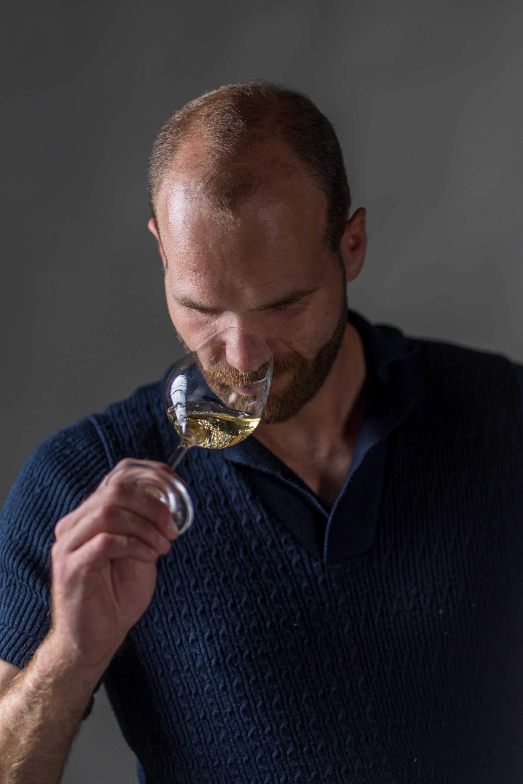 Thibault Ragot, caviste animateur en Languedoc, dégustation d'un vin blanc dans les oliviers